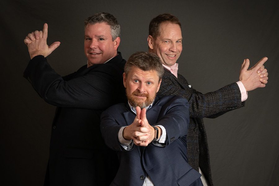 Meet the Team - Agency Owners Portrait in a Funny Stance Acting Like They Are Holding Guns