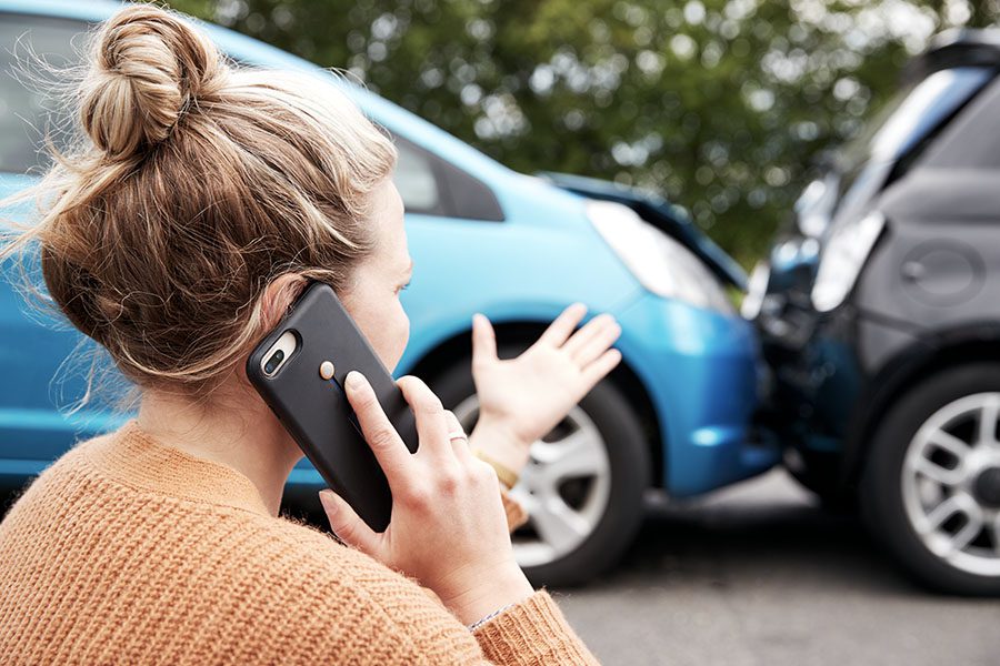 In Case of Emergency - Female Motorist Involved in a Car Accident and Calling Her Insurance Company for Recovery Service