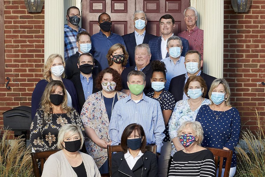 Meet the Team - Manry Heston Agency Team Portrait with Masks in Front of Office Building Door